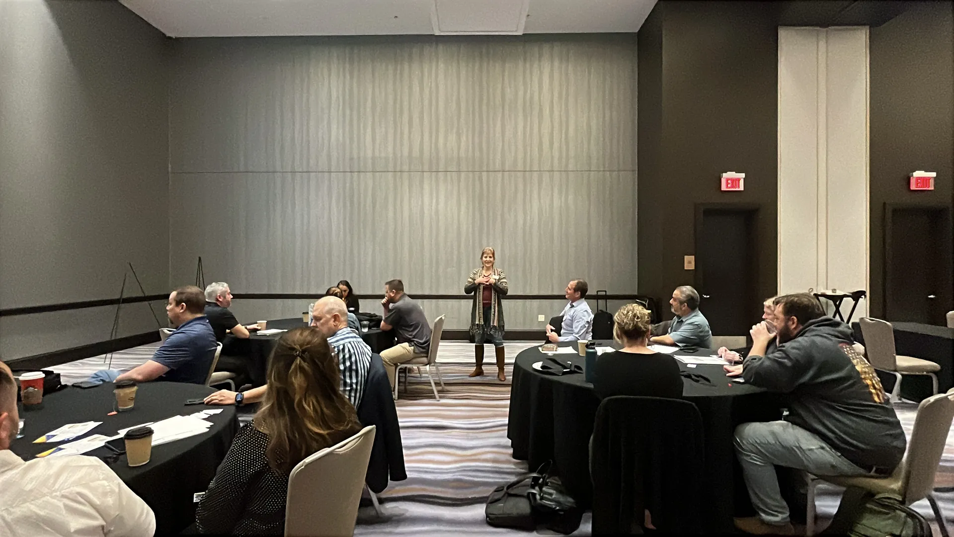 Mona teaching a large group in a conference center about positive psychology and breathwork