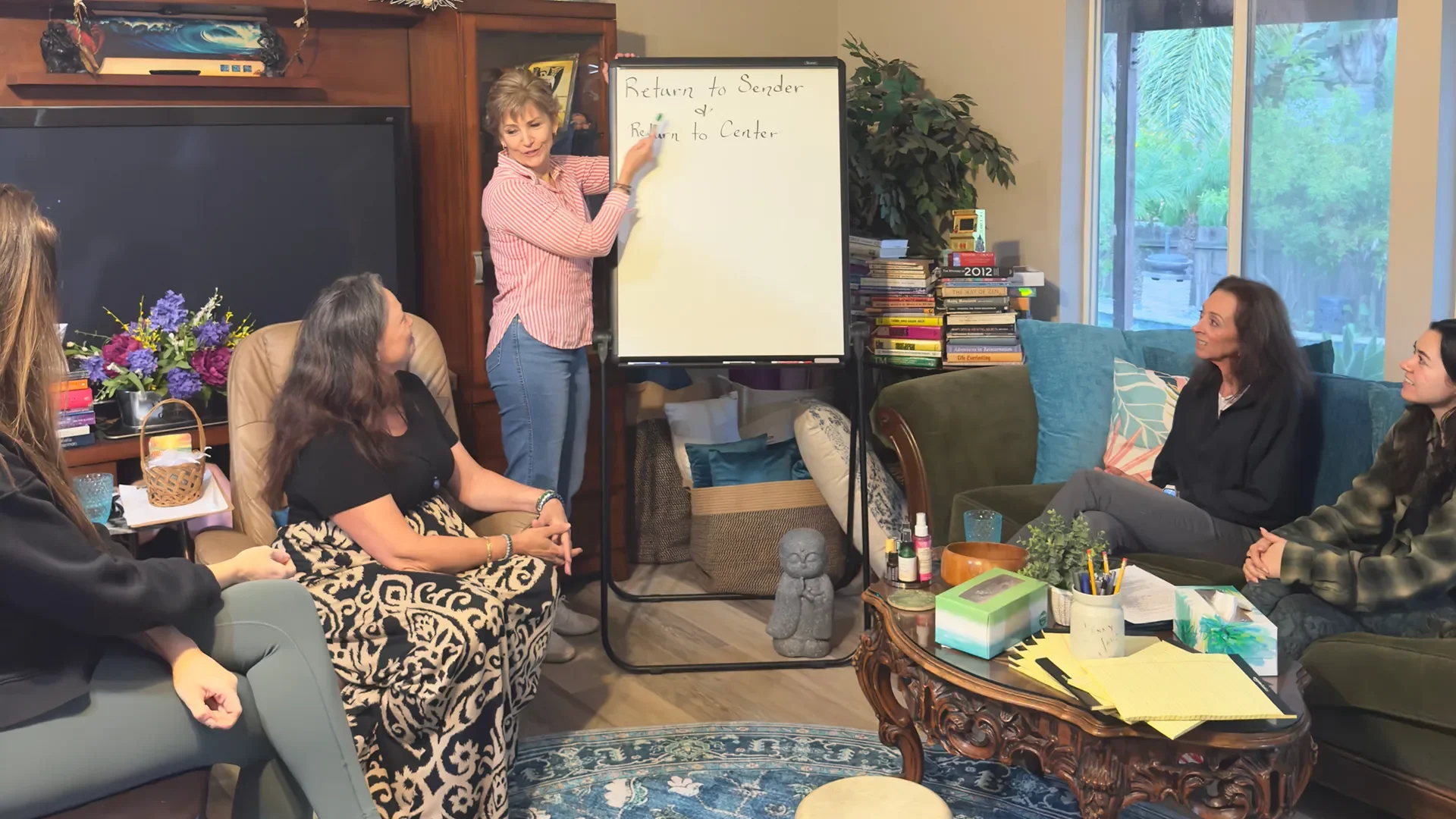 Mona teaching a session in someone's home to a small group about "Return to Sender & Return to Center"